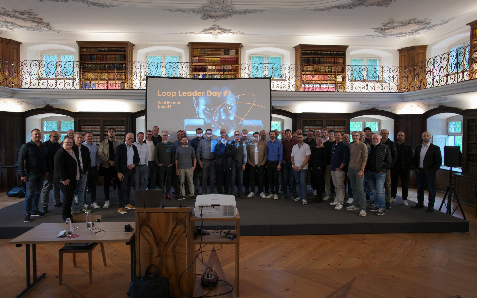 Experiences: Teilnehmende an einem Anlass vor der Leinwand