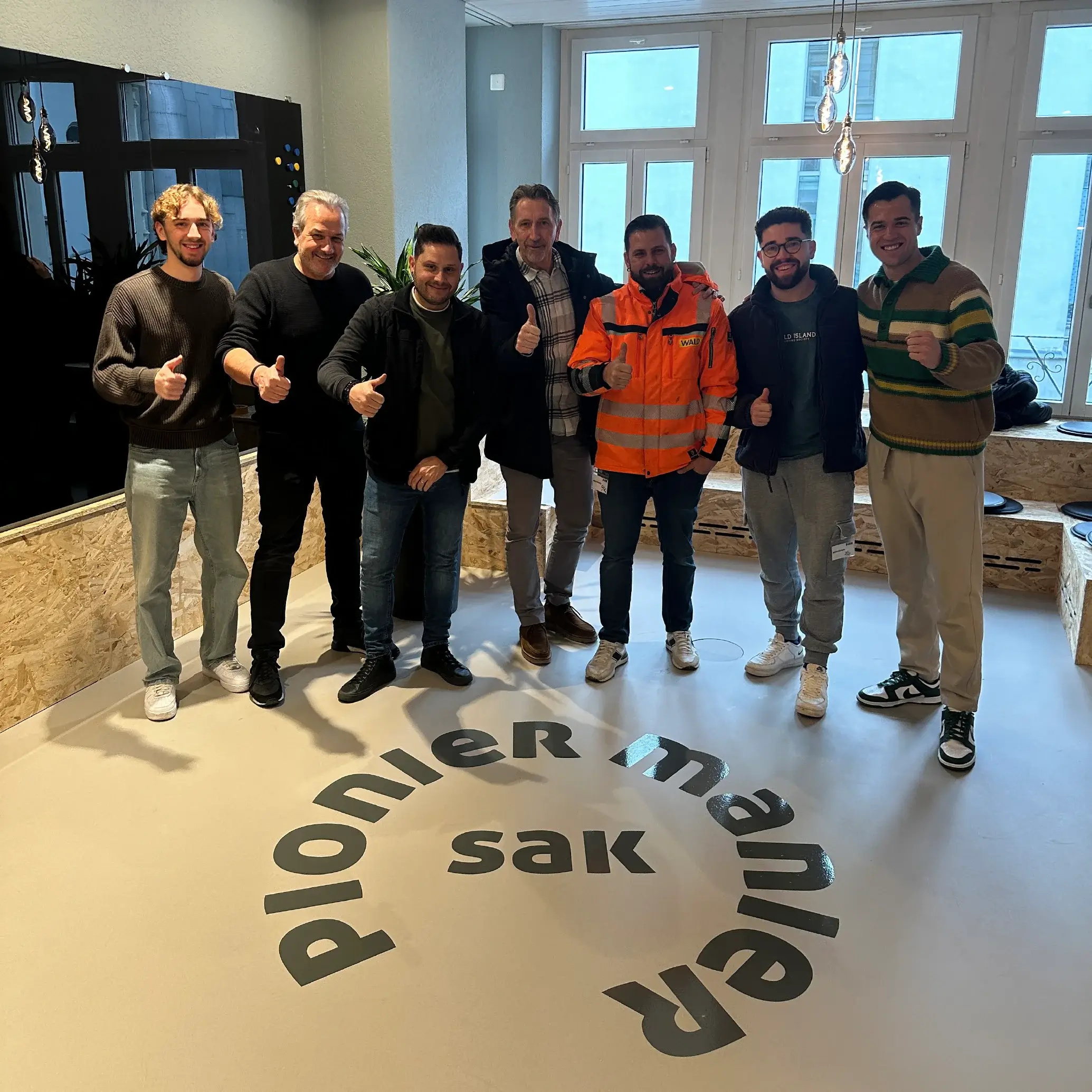 SAK Gruppe: Team auf dem Schriftzug «Pionier-Manier»