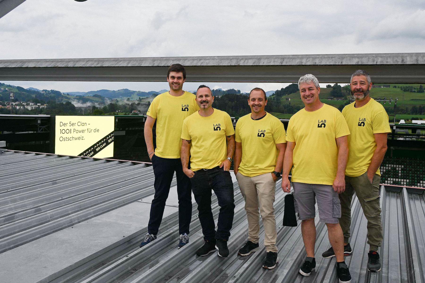 5er Clan: Team in gelben Shirts vor Bergpanorama