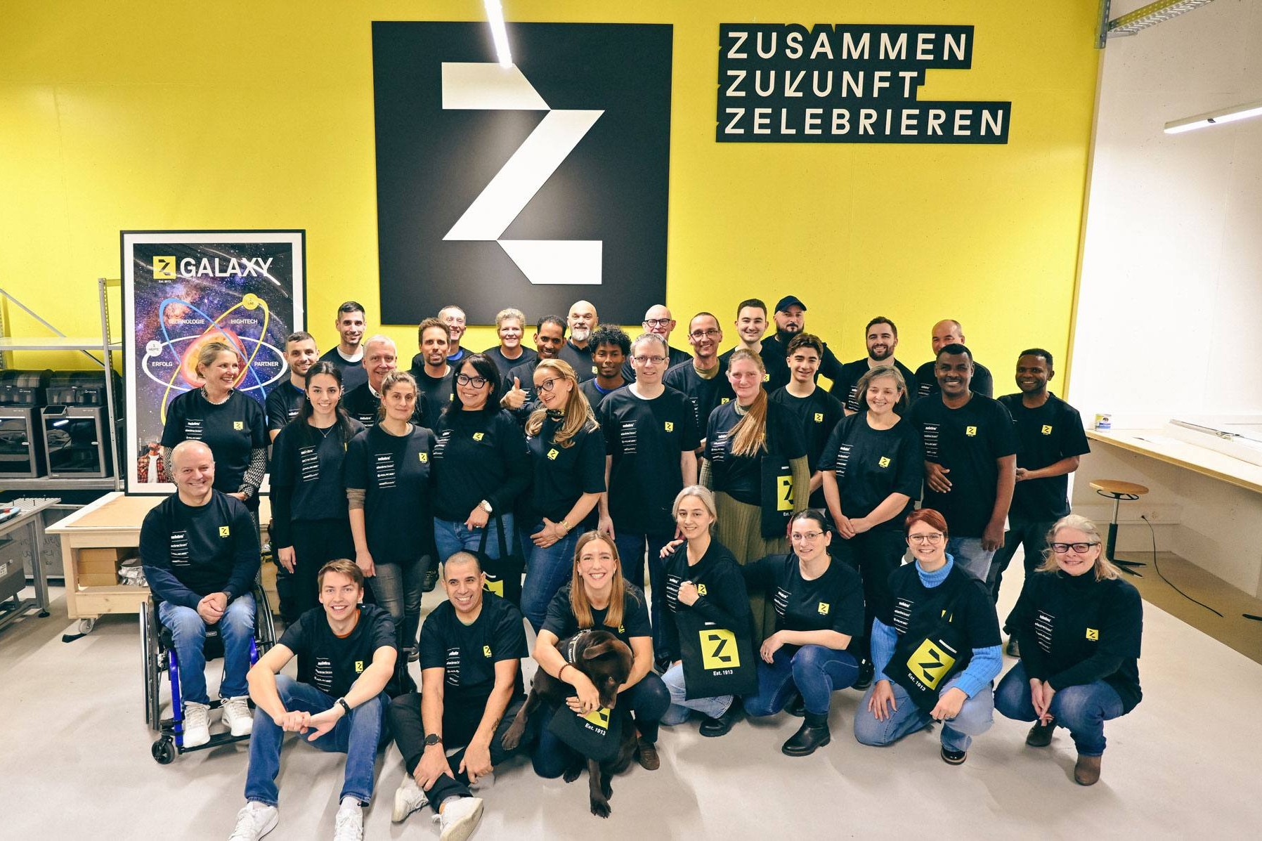 Z-Group: Gruppenfoto der Mitarbeitenden vor dem Z-Logo
