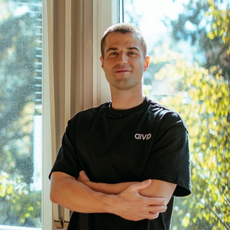 Tobias Krüsi, Development Lead bei Divid in St. Gallen, steht mit verschränkten Armen am Fenster